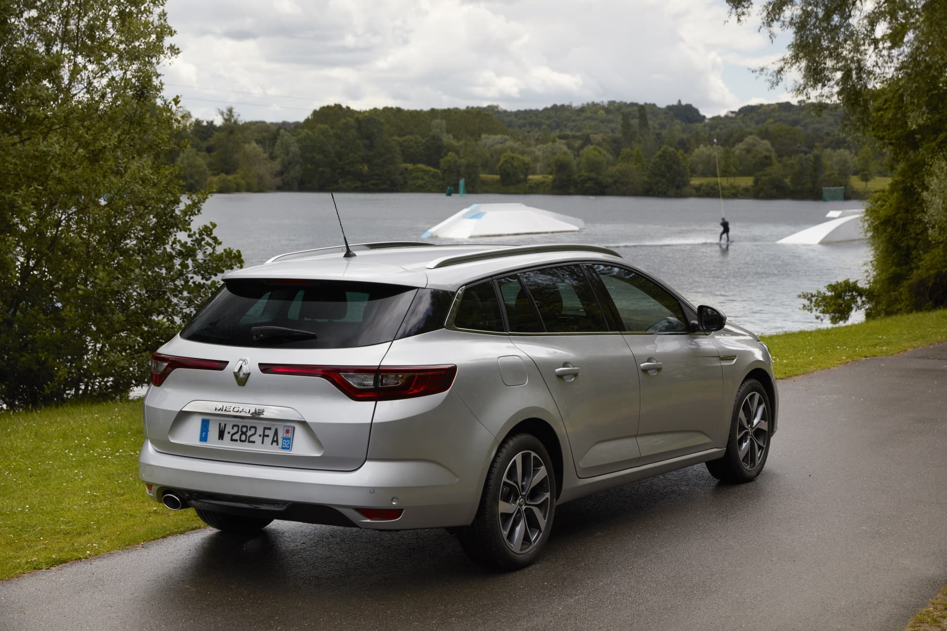 Vista trasera y lateral del Renault Mégane con un fondo de lago y vegetación.