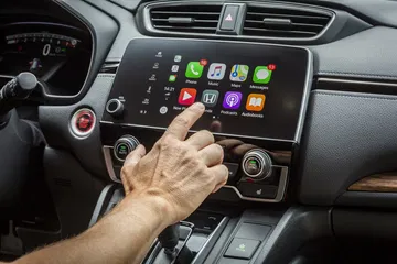 Vista del sistema de entretenimiento del Honda CR-V con una mano ajustando controles.