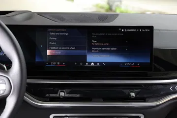 Vista cercana del sistema infotainment BMW X5, destacando su pantalla y funciones.