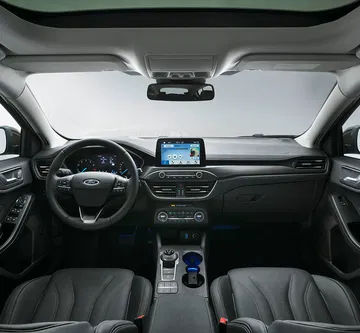 Vista frontal del habitáculo destacando volante y sistema de infotainment.