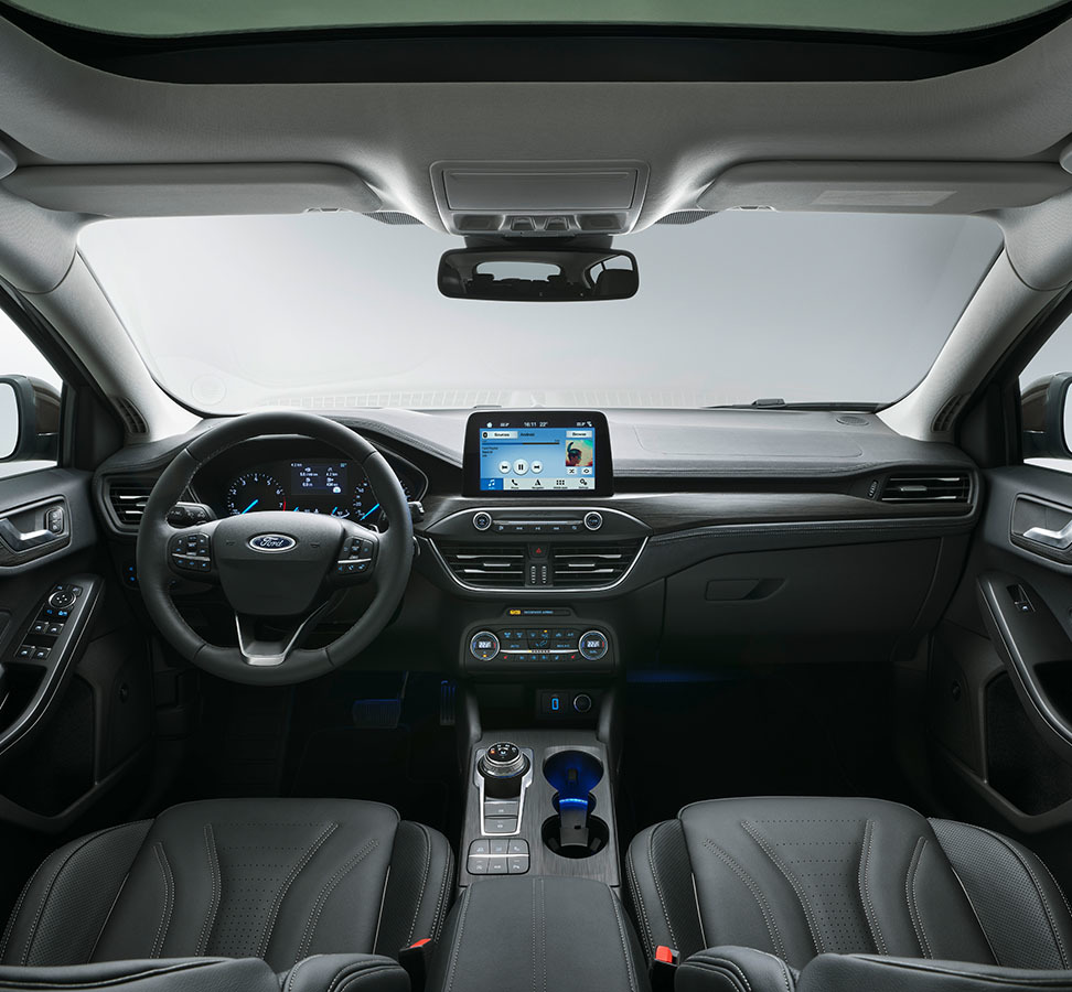 Vista frontal del habitáculo destacando volante y sistema de infotainment.