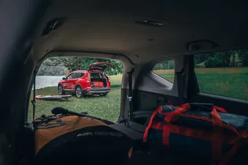 Vista del habitáculo trasero desde el maletero, enfocando otro CR-V al exterior.