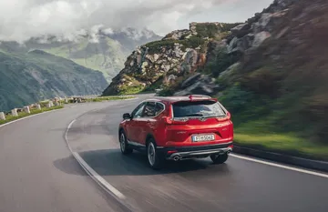 Honda CR-V mostrando su dinámica línea trasera y lateral en carretera.