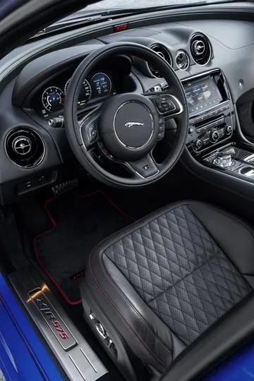 Volante y detalles de acabado en el interior de un Jaguar XJ, con costuras destacadas.