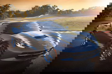Vista dinámica de un Corvette a amanecer en pista, destacando su diseño frontal y lateral.