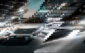 Vista frontal Hyundai Grand Santa Fe iluminando la noche urbana