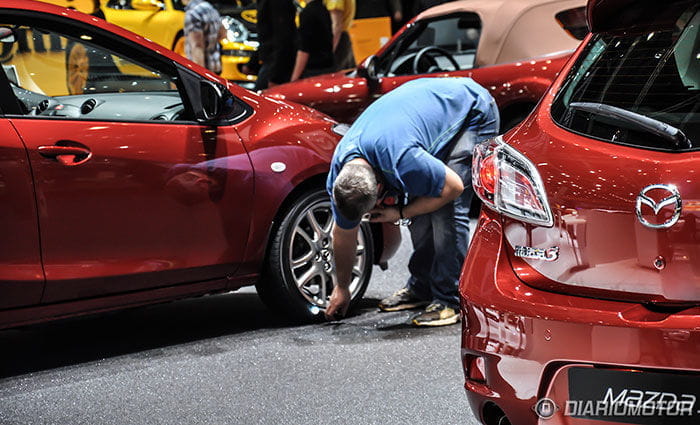 Periodistas y ayudantes mirando debajo de los coches en Ginebra