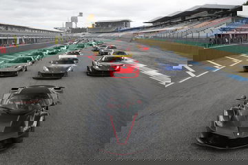 Vista frontal del Ferrari LaFerrari liderando un conjunto de superdeportivos en la pista.