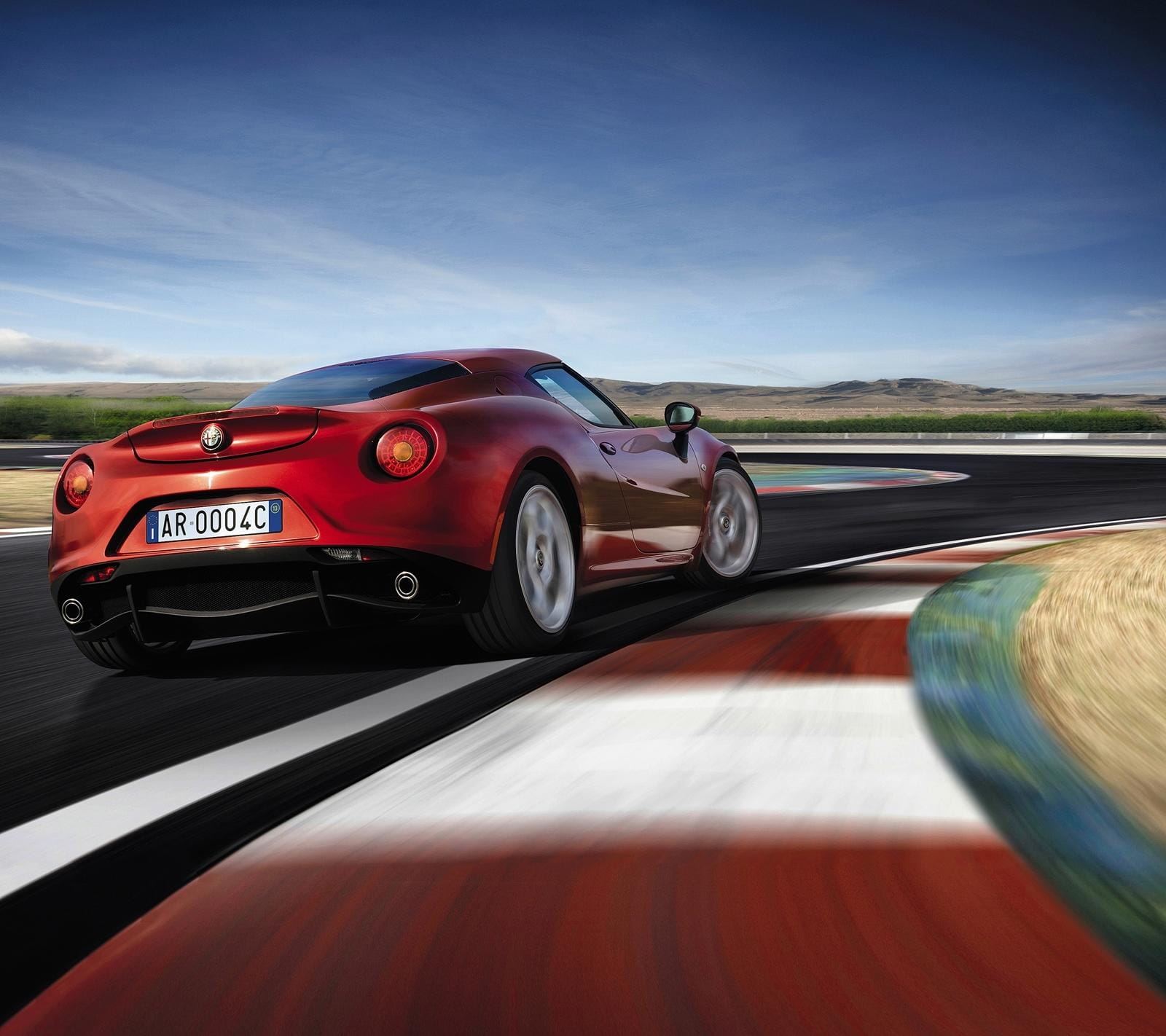 Perfil trasero del Alfa Romeo 4C en pista de carreras, exaltando su diseño deportivo.