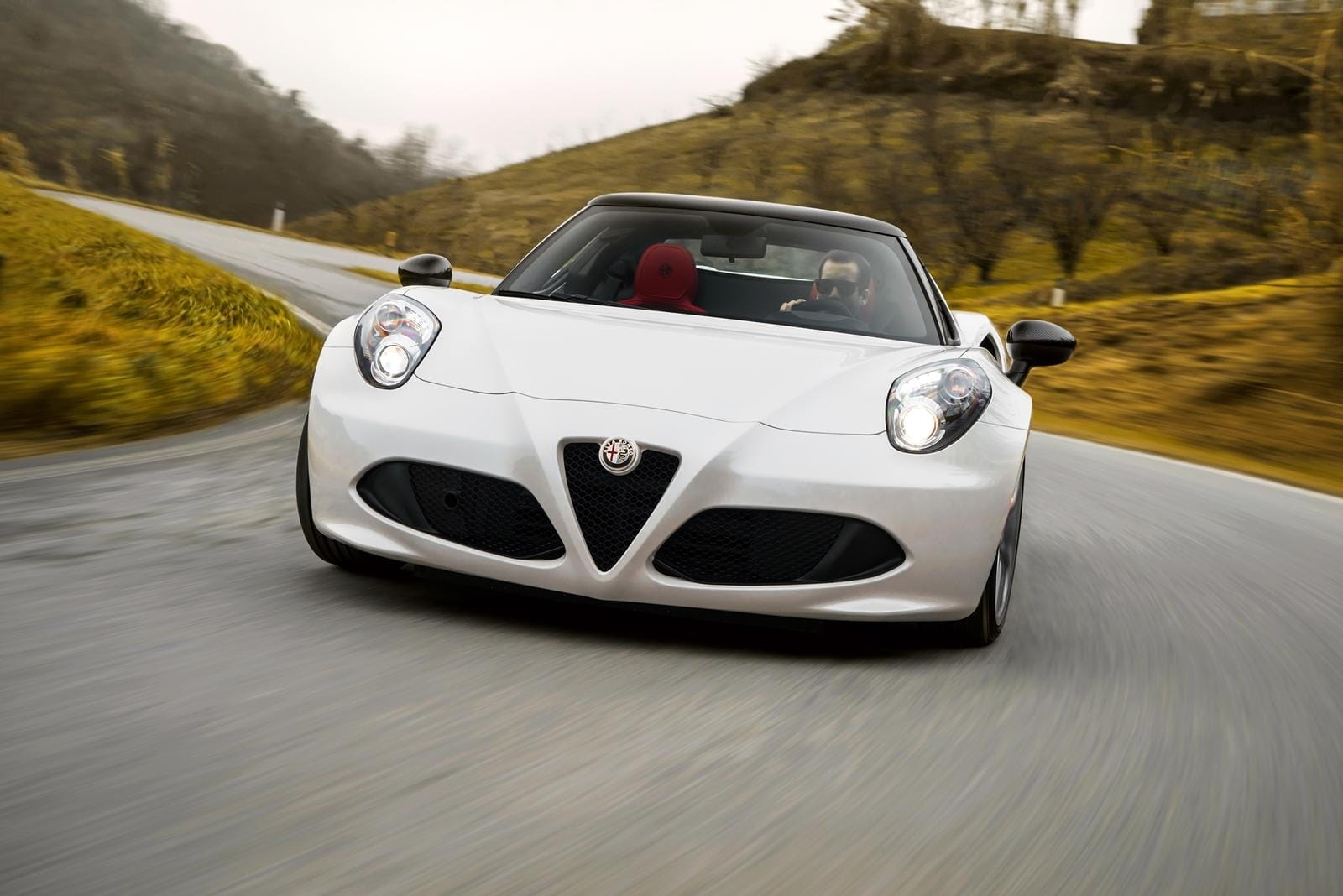 Vista frontal del Alfa Romeo 4C en carretera, destacando su diseño deportivo.