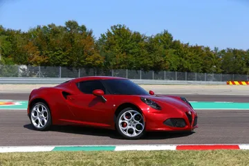 Vista lateral del Alfa Romeo 4C en un circuito, destacando su perfil deportivo.