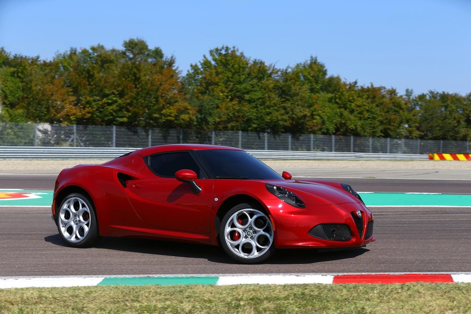 Vista lateral del Alfa Romeo 4C en un circuito, destacando su perfil deportivo.