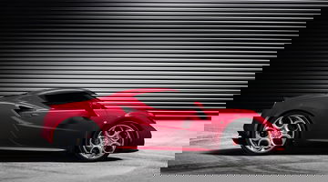 Vista lateral del Alfa Romeo 4C destacando su diseño deportivo y aerodinámico.
