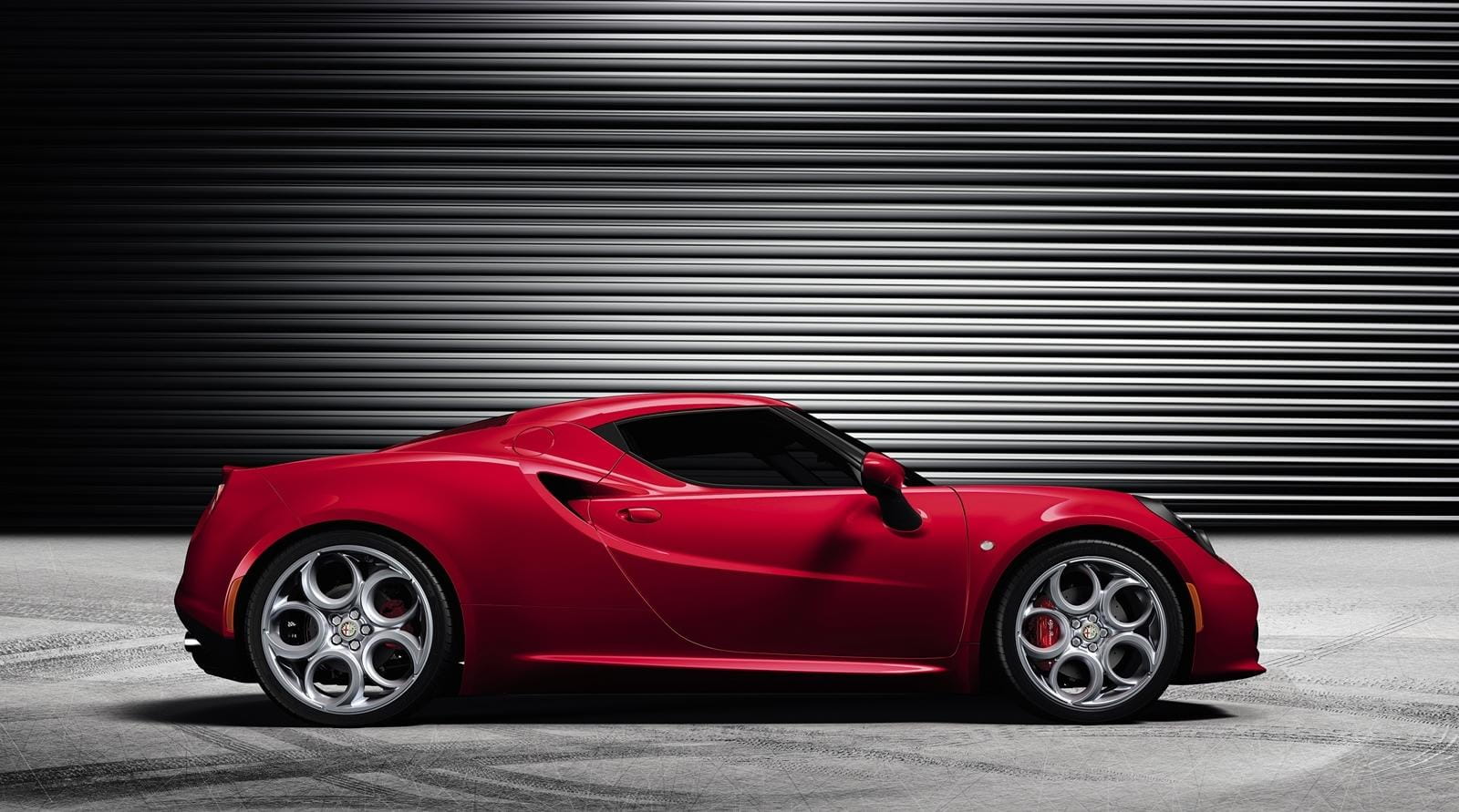 Vista lateral del Alfa Romeo 4C destacando su diseño deportivo y aerodinámico.