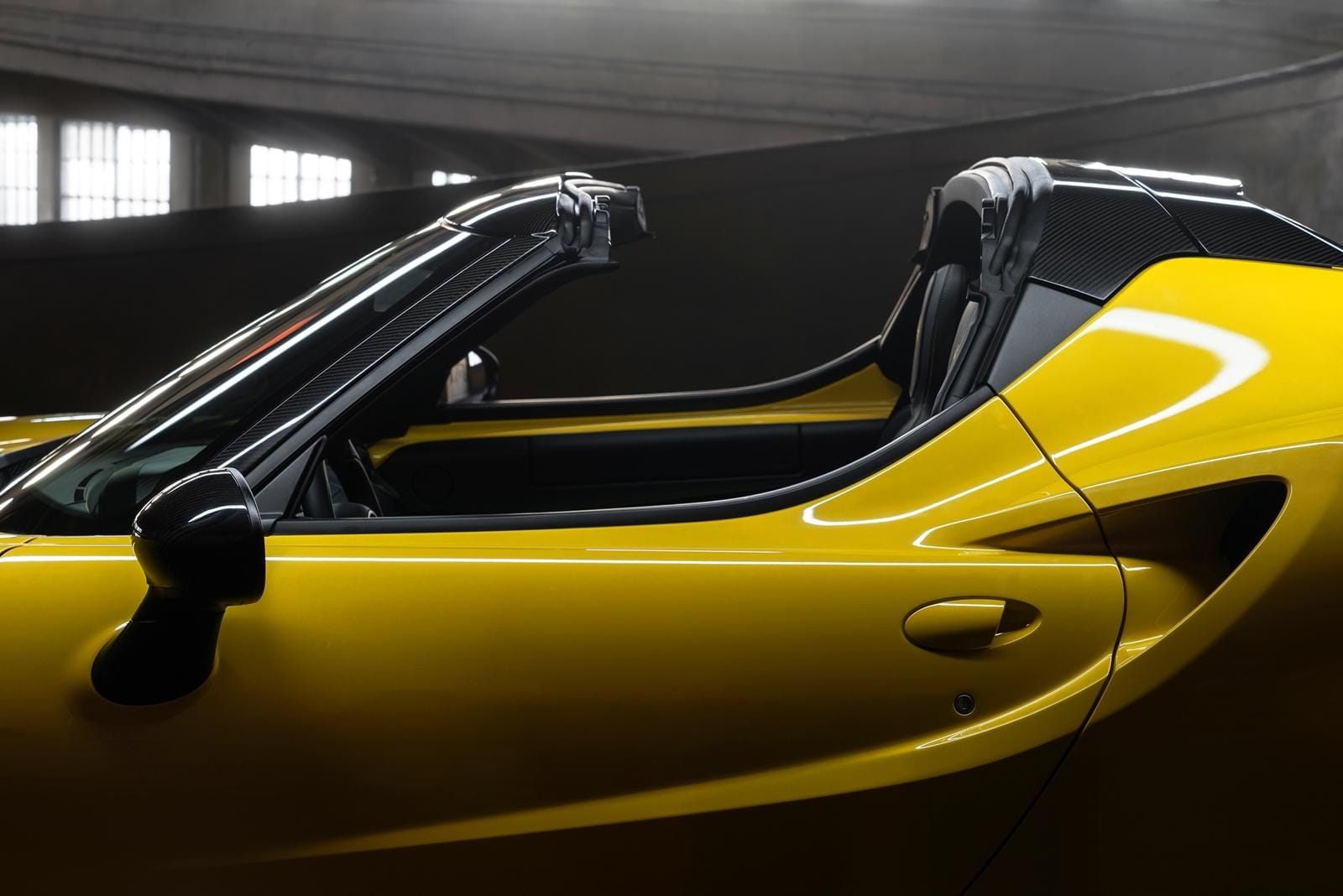 Vista lateral del Alfa Romeo 4C con el techo descubierto que realza su diseño.