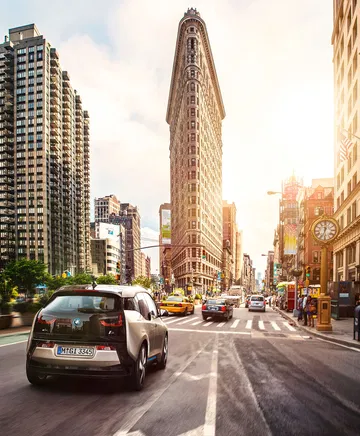 Vista lateral del BMW i3 en un entorno urbano, destacando su adaptabilidad al asfalto citadino.