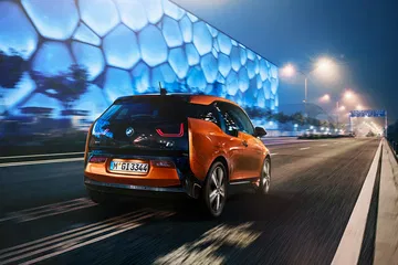 Vista dinámica trasera y lateral del BMW i3 en conducción nocturna.