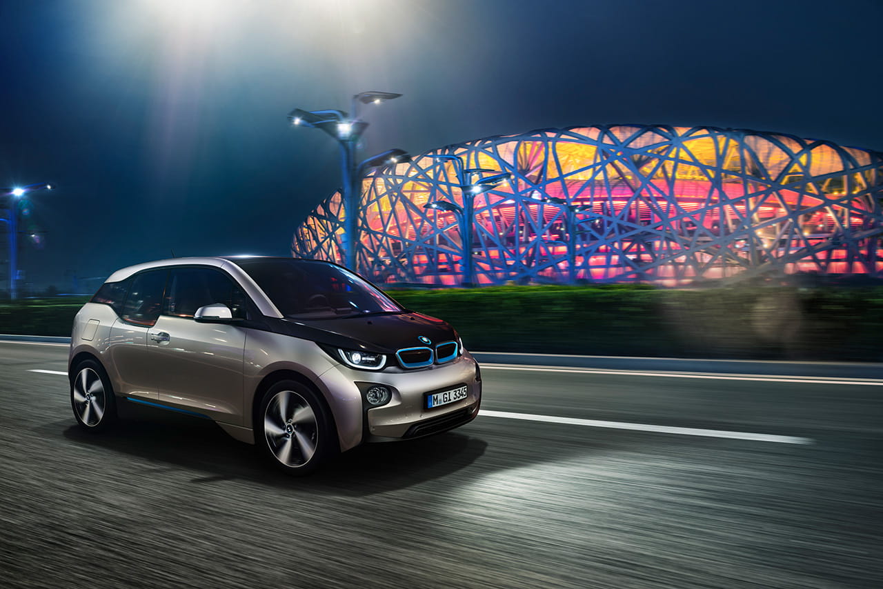 Conducción nocturna del BMW i3 iluminando su dinámica silueta lateral y frontal.