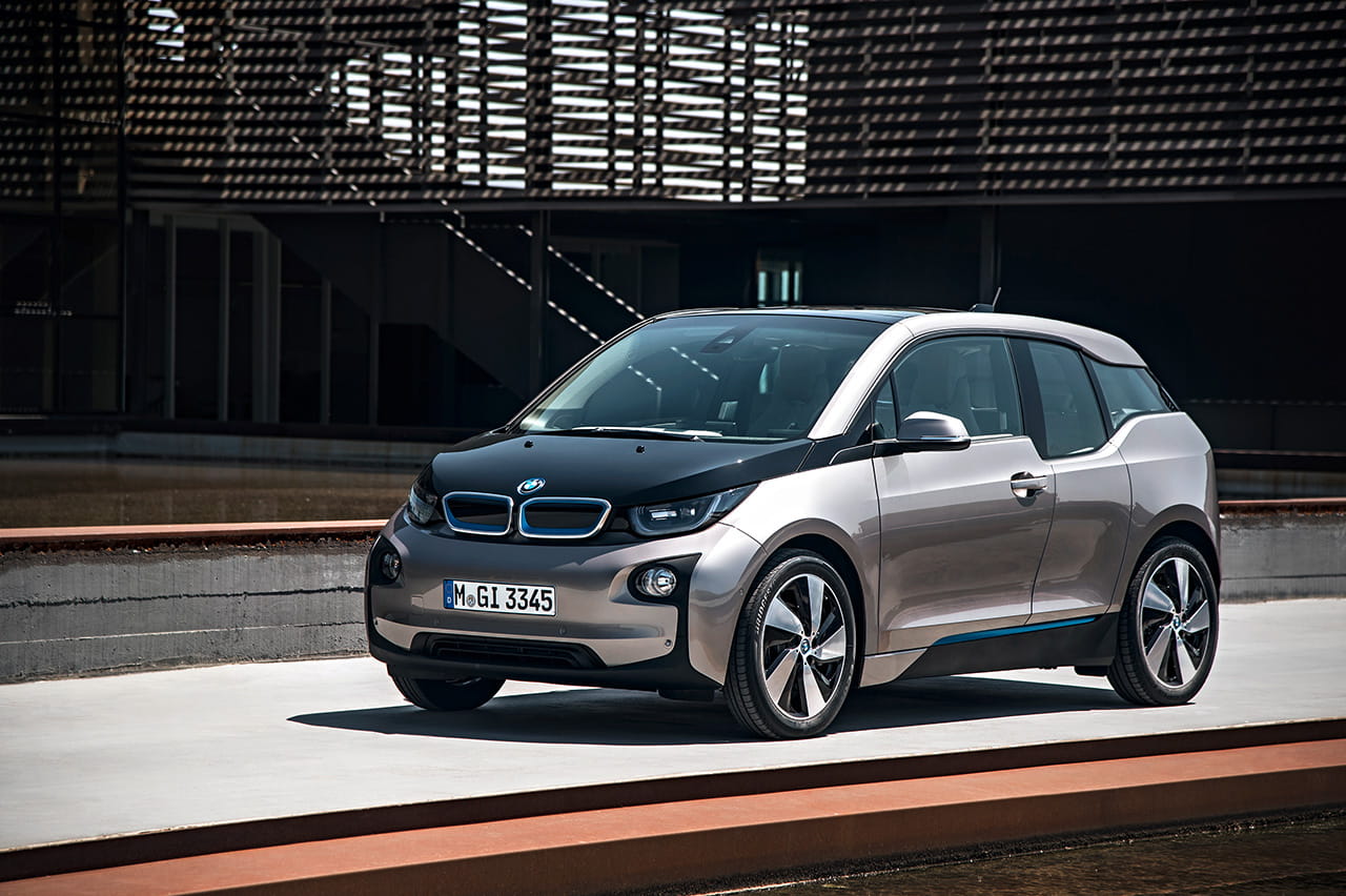 Vista lateral y frontal del BMW i3 resaltando su diseño vanguardista y llantas aerodinámicas.