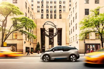 Vista lateral del BMW i3 en un entorno urbano, destacando su diseño compacto.