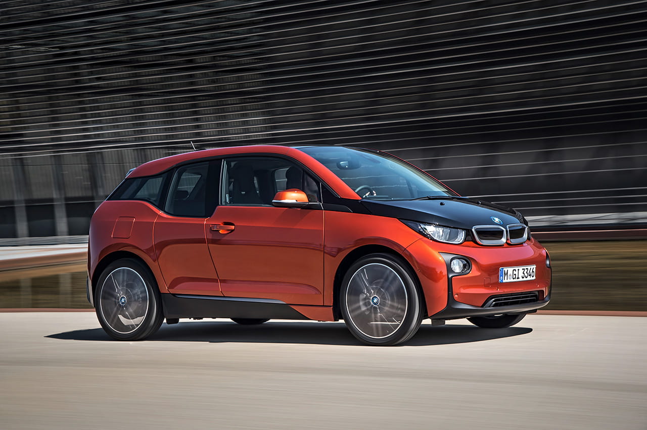 Vista dinámica lateral del BMW i3 en movimiento, destacando su diseño compacto.