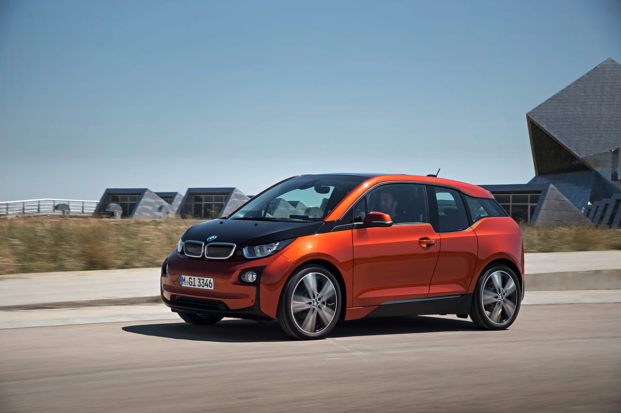 Vista lateral del BMW i3 en movimiento destacando su diseño compacto y dinámico.