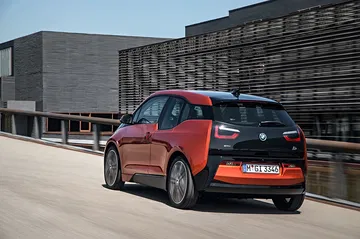 Vista trasera y lateral del BMW i3 con un diseño vanguardista en un entorno urbano