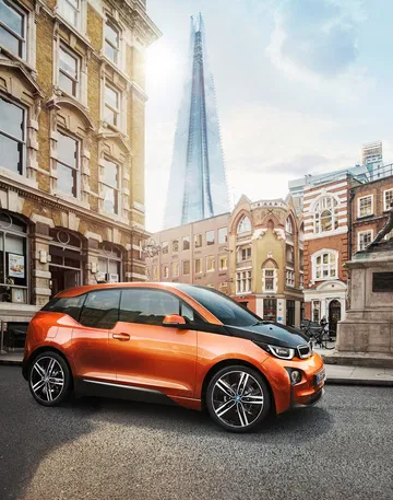 Vista lateral de un BMW i3 en un entorno urbano, destacando su diseño compacto y moderno.