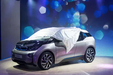 El BMW i3 en su presentación mundial, velado parcialmente revelando la delantera y lateral.