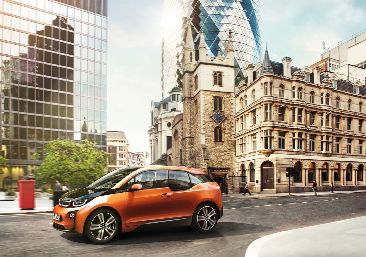 Vista lateral del BMW i3 en un escenario urbano, resaltando su diseño compacto y moderno.