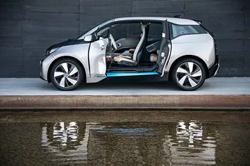 Vista lateral del BMW i3 mostrando su diseño único y puertas de apertura opuesta.
