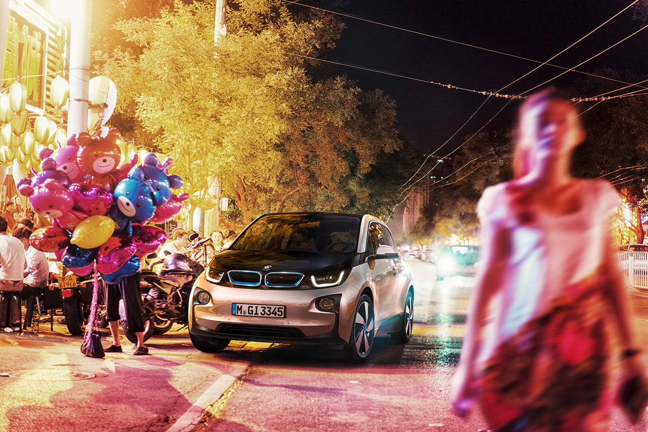 BMW i3 capturado en un entorno urbano nocturno, destacando su diseño frontal lateral.