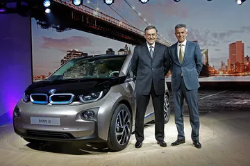 Vista frontal del BMW i3 en evento de presentación junto a ejecutivos.
