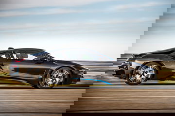 Vista lateral del BMW i8 en movimiento mostrando su línea aerodinámica.