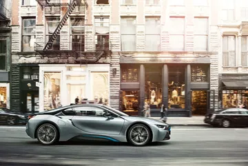 Vista lateral del BMW i8 realzando su diseño futurista en un entorno urbano.