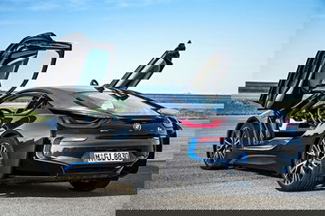 Vista trasera-lateral del BMW i8 con puertas de ala de gaviota abiertas.