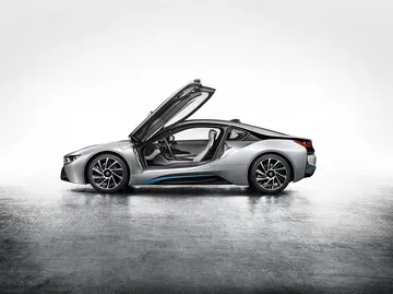 BMW i8 con puertas tipo ala de gaviota abiertas, diseño futurista.