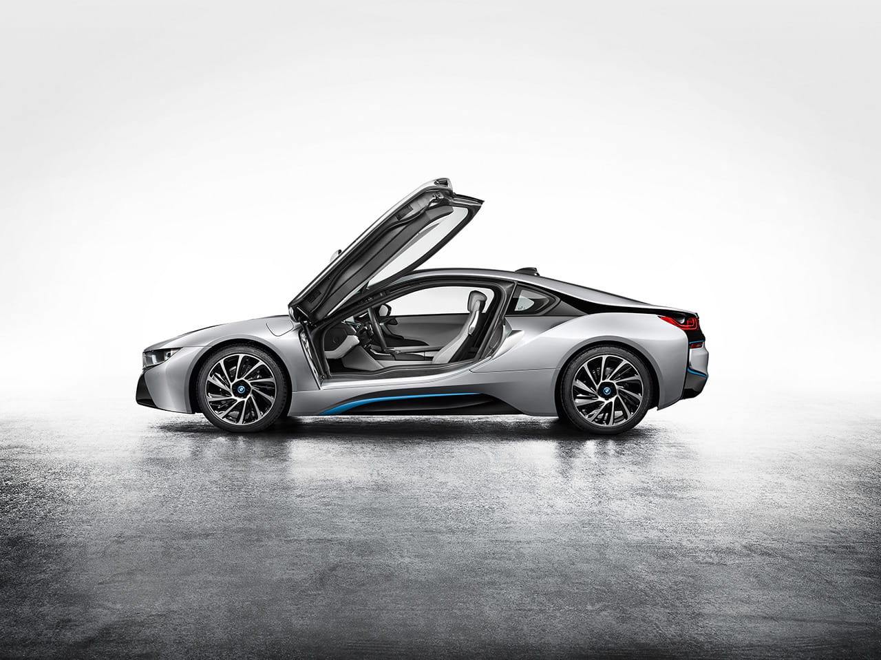 BMW i8 con puertas tipo ala de gaviota abiertas, diseño futurista.