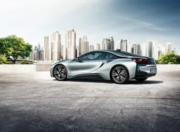 Vista lateral del BMW i8 resaltando su diseño aerodinámico y llantas futuristas.