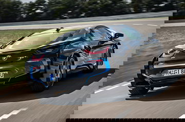 Vista trasera y lateral del BMW i8 en movimiento, realzando su diseño aerodinámico.