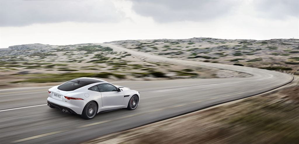 Vista dinámica lateral del Jaguar F-Type Coupé en carretera.