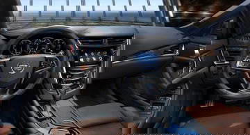 Vista detallada del puesto de conducción del Cadillac CTS con volante y pantalla táctil.