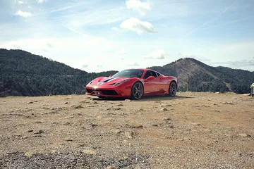 Vista lateral del Ferrari 458 Italia en un entorno natural. Diseño aerodinámico destacado.