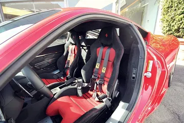 Vista lateral del habitáculo del Ferrari 458 Italia con asientos de cuero rojo.