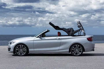 BMW Serie 2 Cabrio con techo convertible abierto, vista lateral.