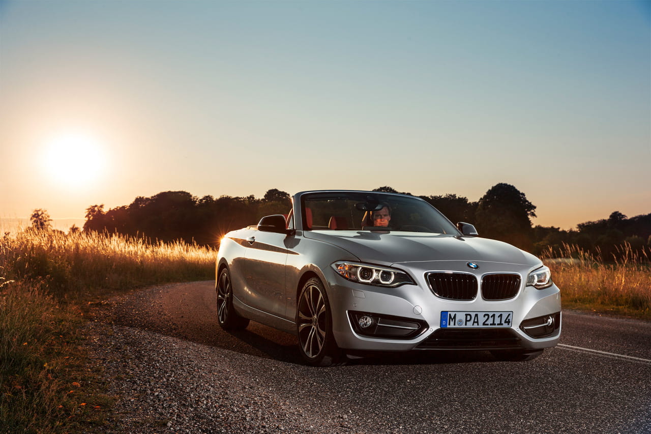 BMW Serie 2 Cabrio captado al atardecer, destaca su diseño frontal y lateral.