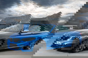 BMW Serie 2 Cabrio en azul con techo plegado mostrando su perfil dinámico.