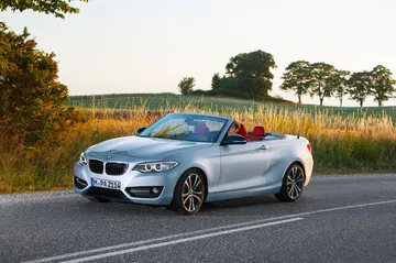BMW Serie 2 Cabrio mostrando su perfil elegante y frontal robusto en marcha.