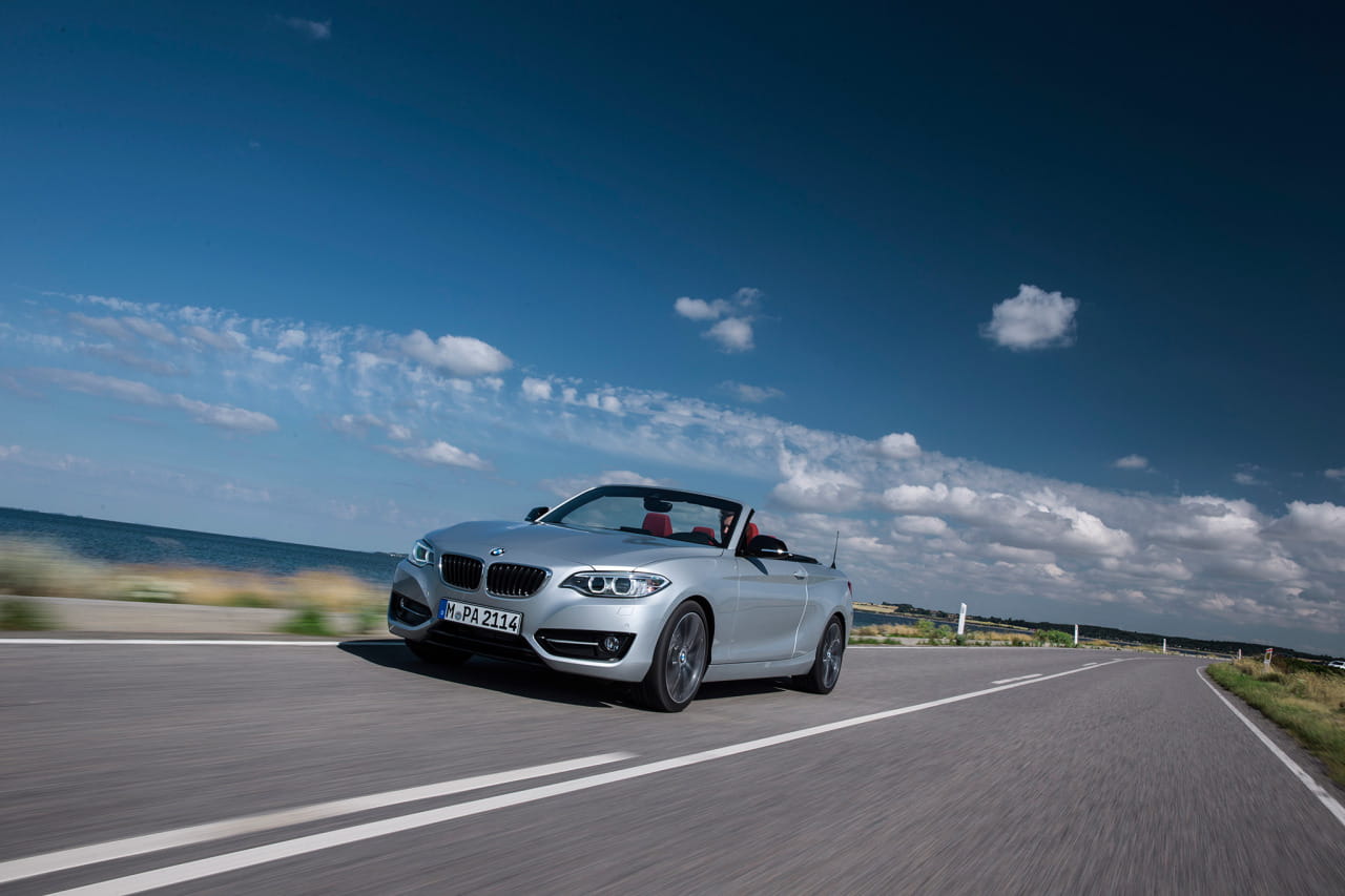 Vista dinámica del BMW Serie 2 Cabrio, enfatizando su diseño frontal y lateral.
