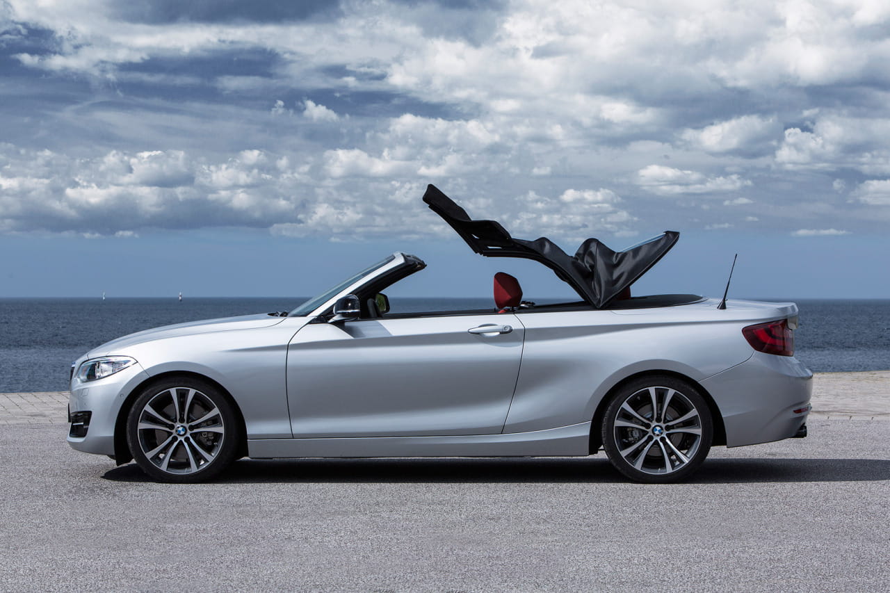 BMW Serie 2 Cabrio capturado desde un ángulo lateral con techo plegado.